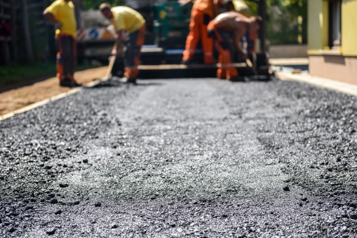 Team of Workers making and constructing asphalt road construction.